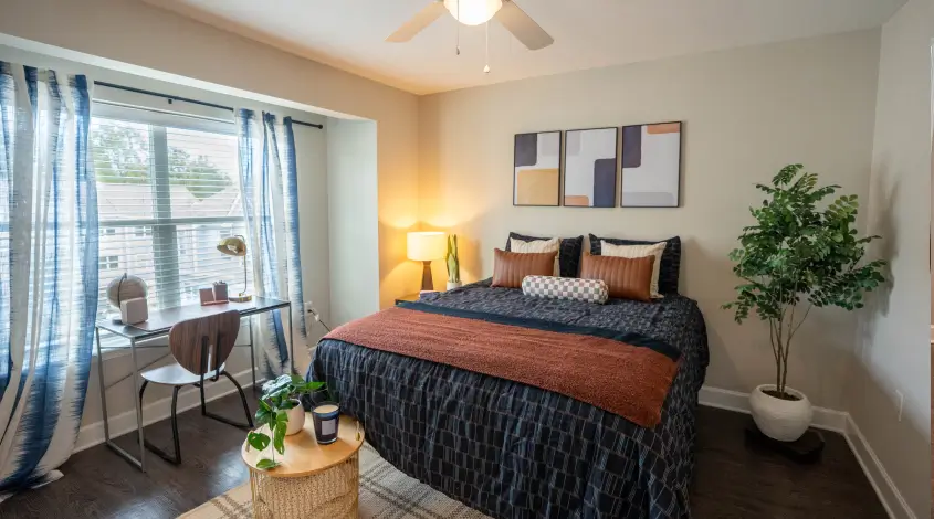 A fully furnished student apartment bedroom with a study desk