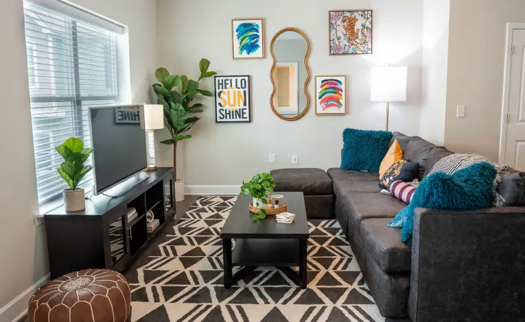 a fully furnished apartment living room with a TV