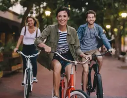 three young adults riding bicycles