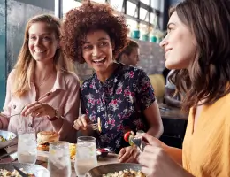 a group of young adults smiling at an indoor restaurant