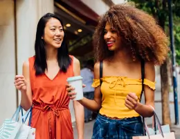 two women holding shopping bags outside
